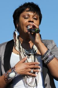 Crystal Waters chantant sur scène avec un microphone