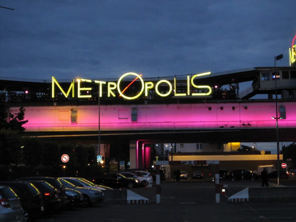 Façade extérieure du Metropolis à Rungis, avec le nom METROPOLIS entièrement visible en néon jaune au-dessus du parking