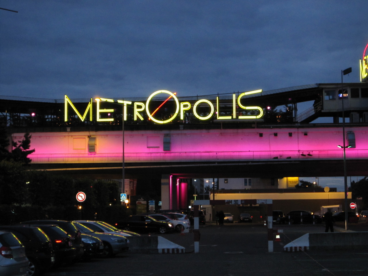 Façade extérieure du Metropolis à Rungis, avec le nom METROPOLIS entièrement visible en néon jaune au-dessus du parking